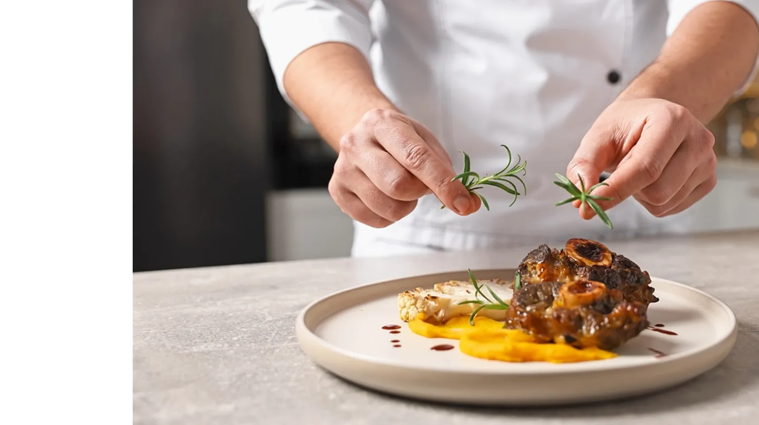 A professional private chef meticulously garnishing a beautifully plated gourmet meat and puree dish with fresh rosemary for a bespoke luxury dinner.